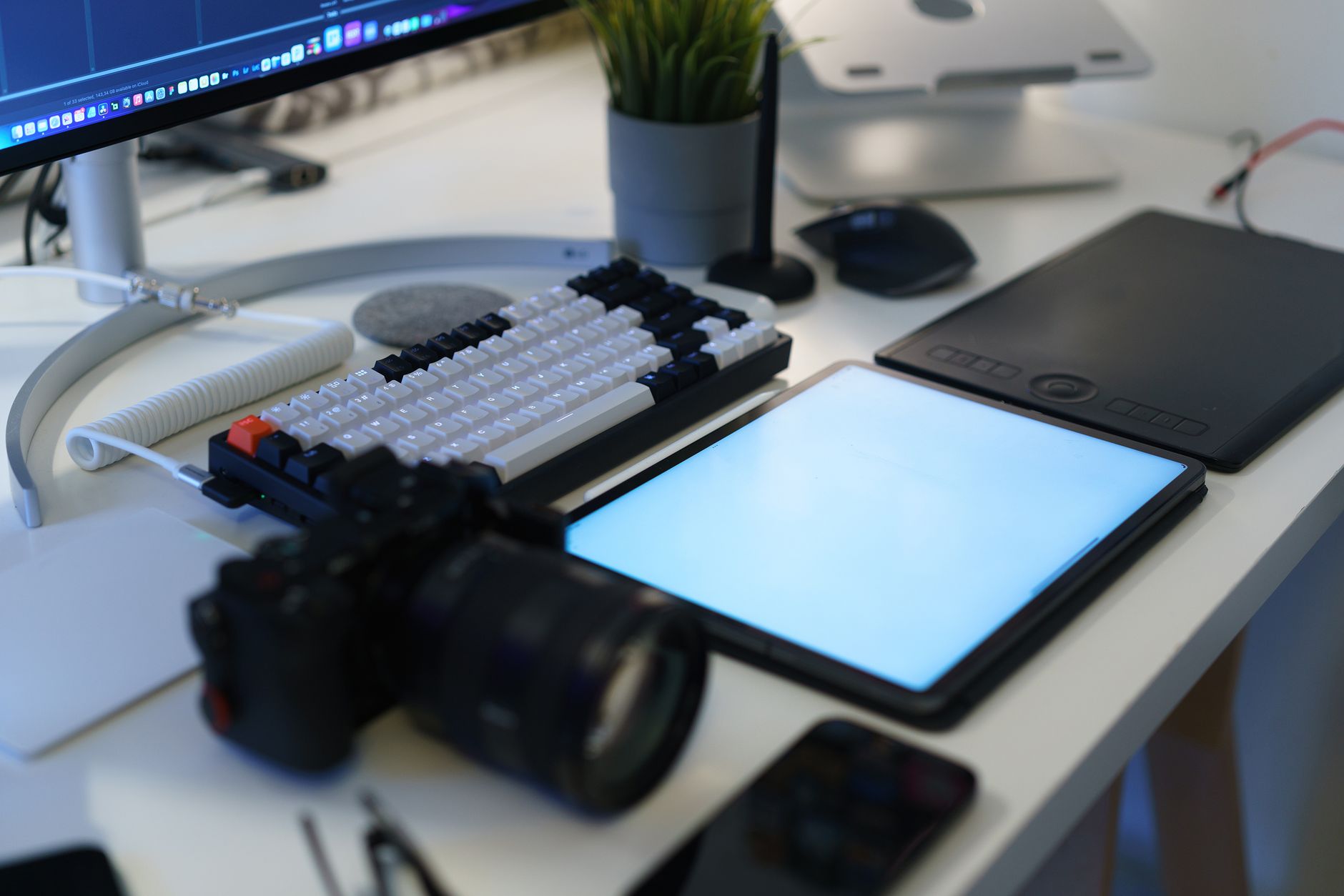 Bureau à domicile moderne avec matériel photo, tablette graphique et clavier ergonomique.
