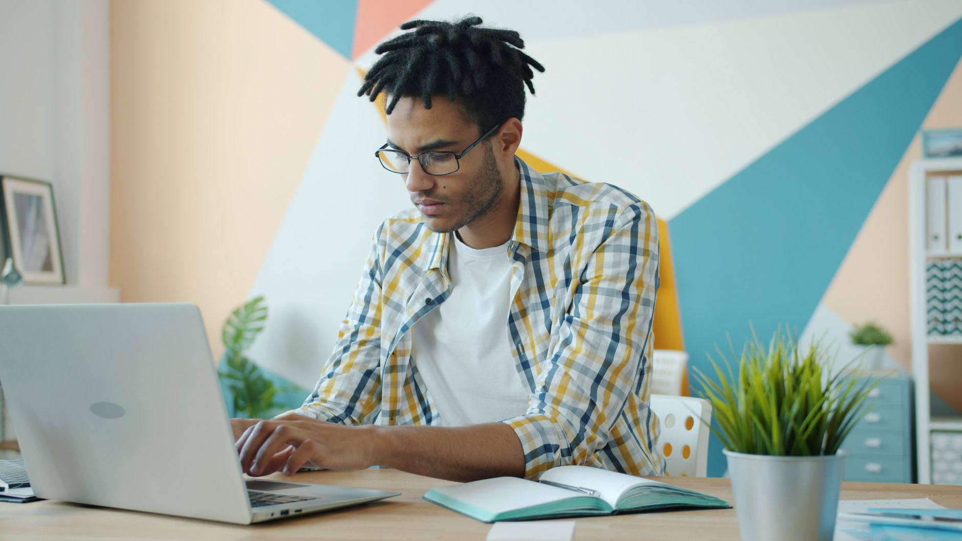 Jeune professionnelle dans un bureau moderne, concentrée et productive sur son ordinateur portable.